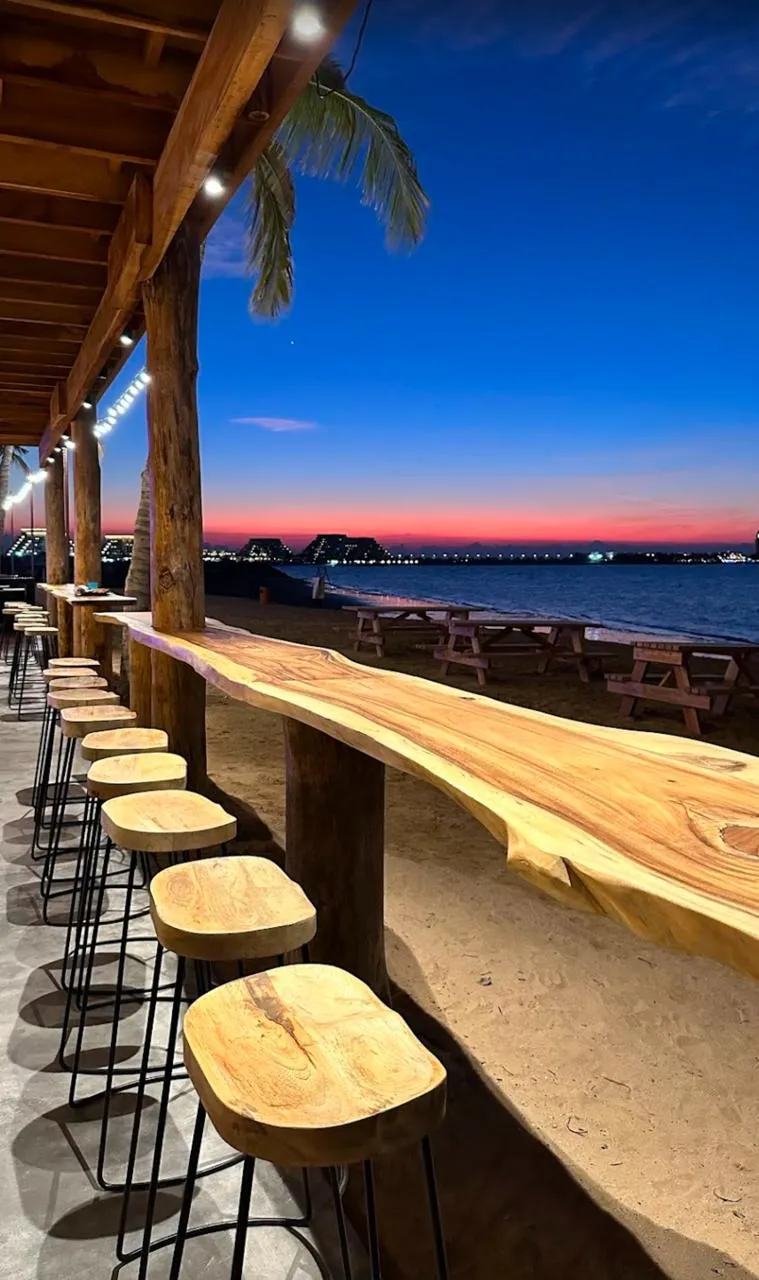 Sunset beach bar with reed-roof timber structure on a UAE beachfront